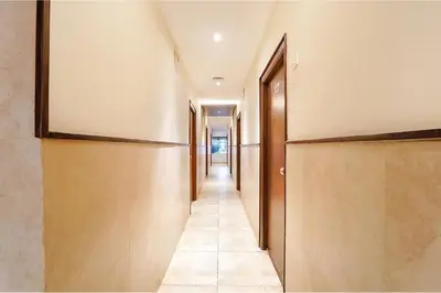 a hallway with wooden doors and a tile floor at FabHotel Karpagam - 900m from Nehru Stadium in Coimbatore