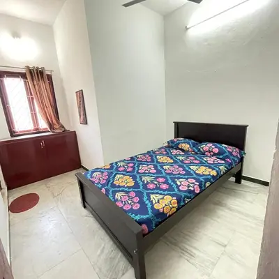 a bedroom with a bed with a colorful comforter at WHITE HOUSE - 3BHK Elegant Apartment in Coimbatore