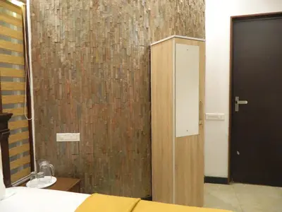 a bedroom with a wooden door and a brown wall at Torch Ginger Homestay in Sultan Bathery