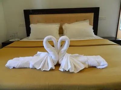 two swansrendered to look like towels on a bed at Torch Ginger Homestay in Sultan Bathery