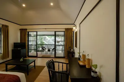 a living room with a table and a dining room at The Hive, Wayanad in Wayanad