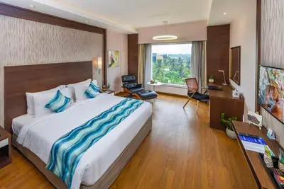 a hotel room with a large bed and a desk at Distrikt 9 in Palakkad