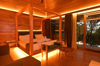 a bedroom with a bed and a couch in a room at Chembarathi Wayanad Boutique Resort in Vaduvanchal