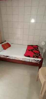 a bed in a room with a red blanket on it at Nakshatra Homestay in Madikeri