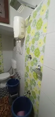 a bathroom with two blue toilets and a sink at Nakshatra Homestay in Madikeri