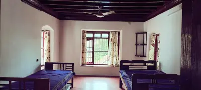 a room with two beds and a window at Aramana Ayurvedic Wellness Centre & Homestay in Palakkad