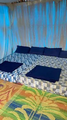 a bed in a tent with blue pillows on it at Lotus Jewel Forest Camping in Sultan Bathery