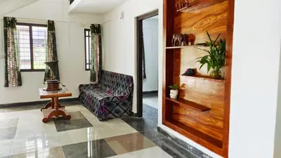 a living room with a couch and a wooden door at Johns Villa in Sultan Bathery