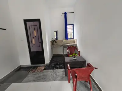 a room with a table and two chairs and a door at Johns Villa in Sultan Bathery