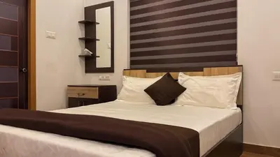 a bedroom with a bed with white sheets and pillows at PARTHO home stay in Padinjarathara