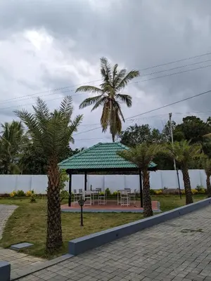 a gazebo with palm trees in a park at Multiple Stories, Wayanad in Wayanad