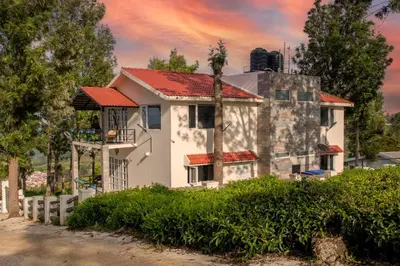 a white house with a red roof at StayVista at Villa Misty Oaks with Breakfast in Ooty