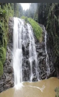 a waterfall in the middle of a river at Devarakadu Valley View by StayApart in Madikeri