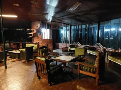 a restaurant with tables and chairs in a room at THE TIGER PAW RESORT in Masinagudi
