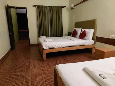 a hotel room with two beds and a window at THE TIGER PAW RESORT in Masinagudi