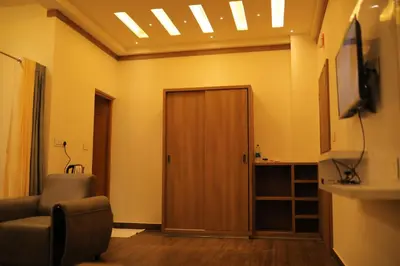 a living room with a door and a television at HYDEPARK REGENCY in Palakkad