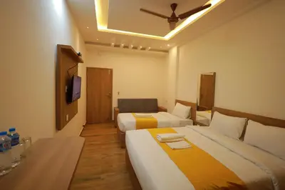 a hotel room with two beds and a tv at HYDEPARK REGENCY in Palakkad