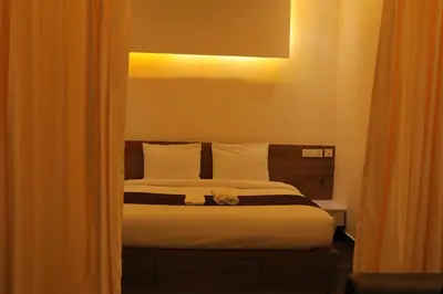 a bedroom with a bed with white pillows at HYDEPARK REGENCY in Palakkad