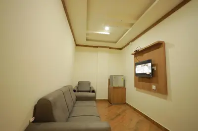 a waiting room with a couch and a tv at HYDEPARK REGENCY in Palakkad