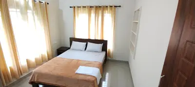 a small bedroom with a bed and a window at Eve's appartment in Meppādi