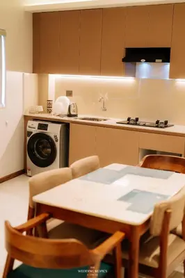 a kitchen with a table and chairs and a washing machine at Alite Enclaves Fully furnished apartments in Trichūr