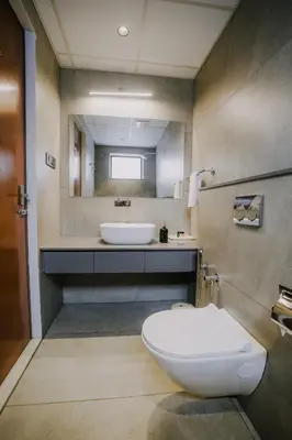 a bathroom with a white toilet and a sink at Alite Enclaves Fully furnished apartments in Trichūr