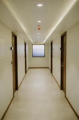 an empty corridor of an office building with doors and a window at Alite Enclaves Fully furnished apartments in Trichūr