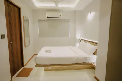 a bedroom with a white bed and a window at Alite Enclaves Fully furnished apartments in Trichūr