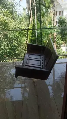 a laptop computer sitting on a swing at CRS RED & WHITE HOMESTAY in Sultan Bathery