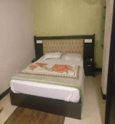 a bed in a room with two towels on it at Redbell suites Residency in Kondotti