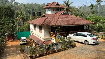 a white car parked in front of a house at Golden Cypress Resort with Pool -Wayanad in Padinjarathara