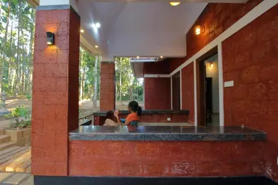 two people sitting at a bar in a building at TreeSong Villa - Tranquil Forest Villa in Wayanad in Sultan Bathery
