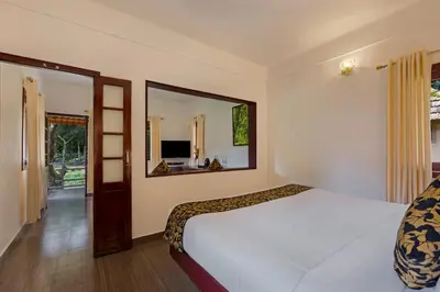 a bedroom with a bed and a large mirror at Sterling Vythiri Wayanad in Wayanad