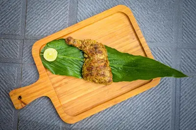 a banana leaf with a piece of food on a cutting board at Sterling Vythiri Wayanad in Wayanad