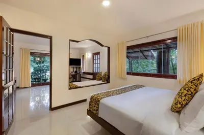 a bedroom with a large bed and a mirror at Sterling Vythiri Wayanad in Wayanad