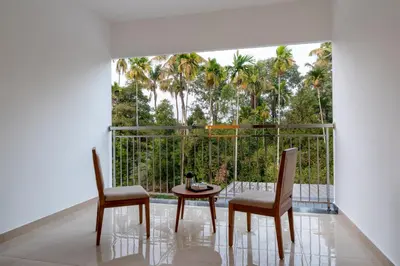 a room with a table and two chairs and a large window at Hotel Panoramic in Ernakulam