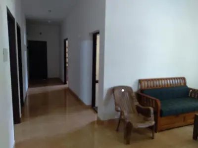 a living room with a blue couch and a chair at Homely Homestay in Kalpetta