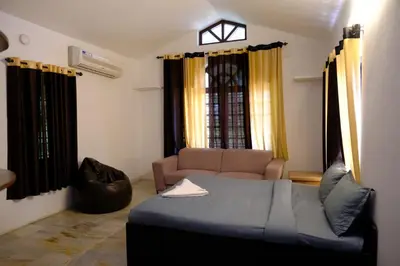 a living room with a bed and a couch at The Wayanad Club in Sultan Bathery