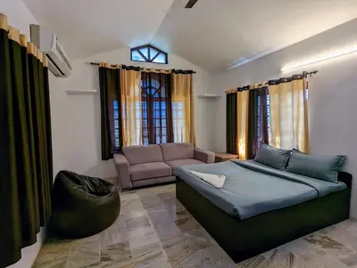 a living room with a bed and a couch at The Wayanad Club in Sultan Bathery