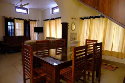 a dining room with a glass table and chairs at The Wayanad Club in Sultan Bathery