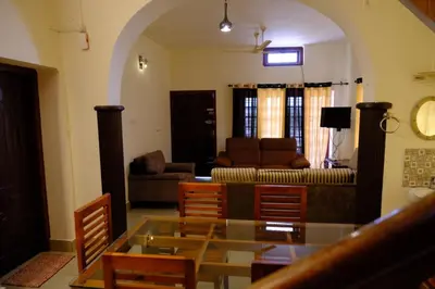 a living room with a couch and a table and chairs at The Wayanad Club in Sultan Bathery