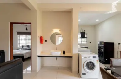 a bathroom with a sink and a washing machine at Amminis Mansion by Doris Homes in Trichūr