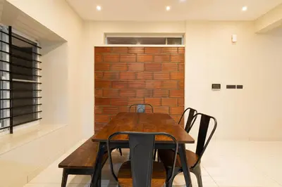 a dining room with a wooden table and chairs at Amminis Mansion by Doris Homes in Trichūr