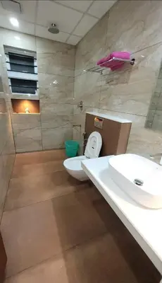 a bathroom with a white toilet and a sink at Amminis Mansion by Doris Homes in Trichūr