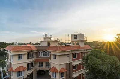 a building with a sunset in the background at Amminis Mansion by Doris Homes in Trichūr