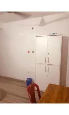 a dining room with a table and a cabinet at Redbell Inn Airport Hotel in Kondotti