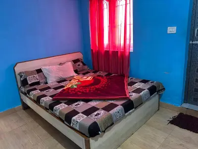 a bed in a room with a red curtain at Wander homes in Ooty