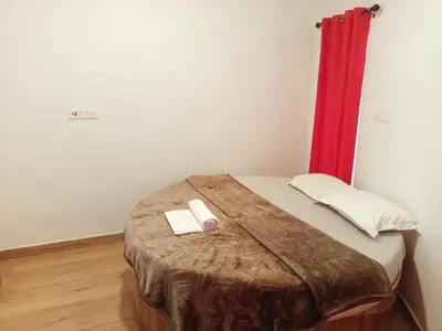 a bed in a room with a red curtain at Wander homes in Ooty