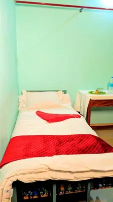 a bed with a red blanket on it in a room at VKR MENS ROOM (Gents Only) in Kozhikode