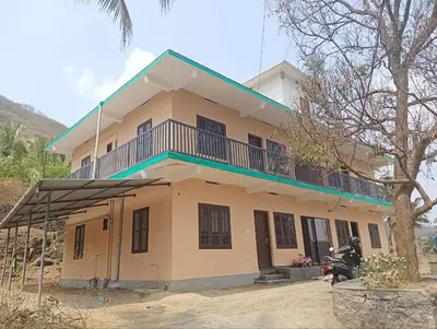 a house with a balcony on top of it at BHASURI VILLA Attappady in Varagampadi